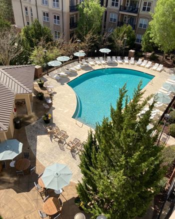 A large swimming pool surrounded by chairs and umbrellas.